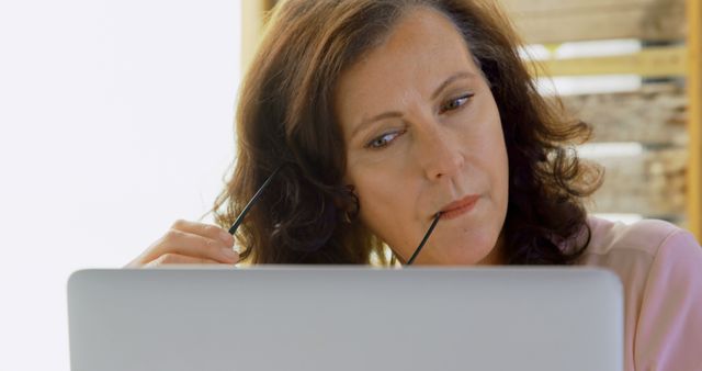 Mature Woman Thinking While Using Laptop for Work - Download Free Stock Images Pikwizard.com