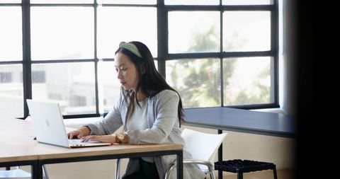 Woman Working on Laptop in Bright Office Workspace