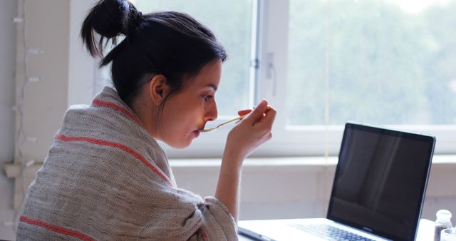 Young Woman Eating Breakfast While Working on Laptop - Download Free Stock Images Pikwizard.com