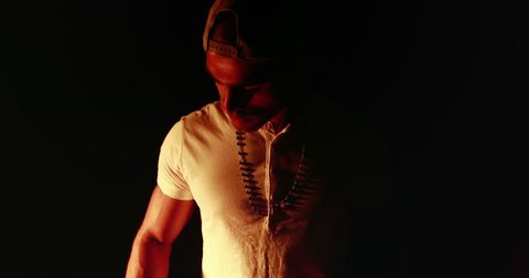 Moody low-light portrait of young man in white t-shirt