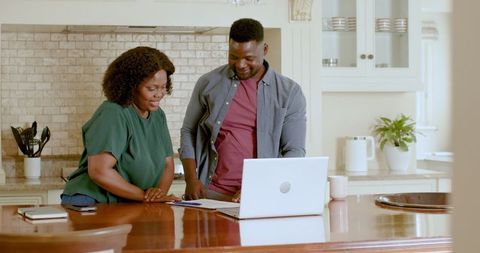 Couple Discussing Plans with Laptop in Kitchen Interior