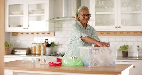 Senior Woman Organizing Recyclables in Modern Kitchen
