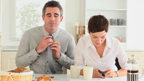 Busy Couple Preparing for Day in Modern Kitchen