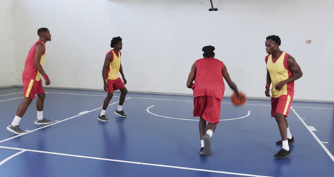 Group of Basketball Players Practicing in Gymnasium