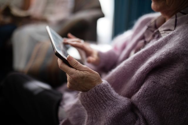 Midsection senior woman using digital tablet at retirement home