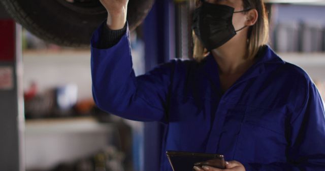 Female Auto Mechanic Inspecting Vehicle Tire in Workshop - Download Free Stock Images Pikwizard.com