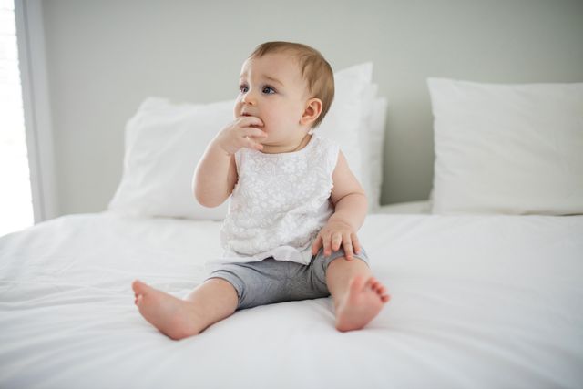 Cute baby girl relaxing on bed - Download Free Stock Photos Pikwizard.com