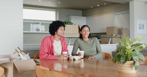 Couple Unpacking Boxes and Enjoying Coffee in Kitchen