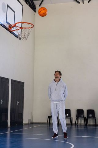 Coach supervising basketball game in gymnasium