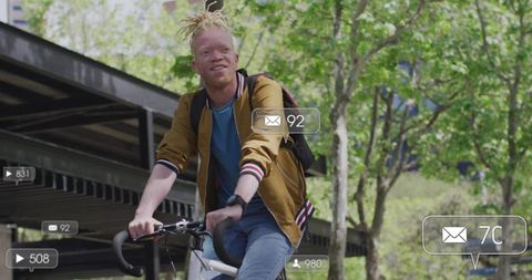 Man with Dreadlocks Riding Bicycle Confidently Outdoors