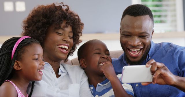 Loved ones spending quality time while taking a selfie at home. Perfect for themes related to family bonding, happiness, technology, and modern family lifestyle. Ideal for use in advertising for tech products, family services, and social media promotions.