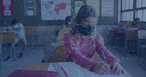 Elementary student wearing face mask writing in classroom with digital network overlay