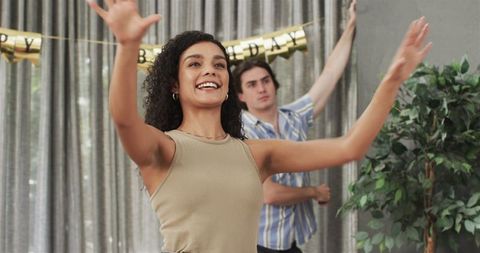 Couple joyfully preparing birthday decorations at home