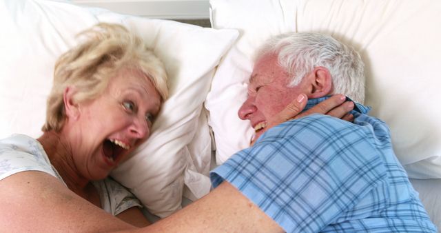 Smiling senior couple in bed together