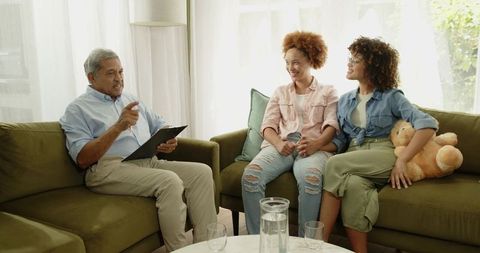 Senior Counselor Conducting Couples Therapy with Two African American Women on Sofa