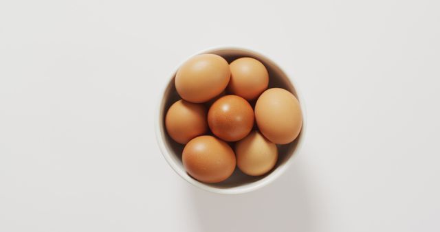 Close up of bowl of brown eggs with copy space on white surface. organic food and nutrition concept