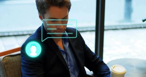 Businessman sitting in cafe checking messages with holographic chat interface and coffee