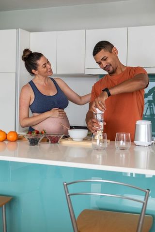 Expecting Couple Preparing Healthy Drink in Modern Kitchen