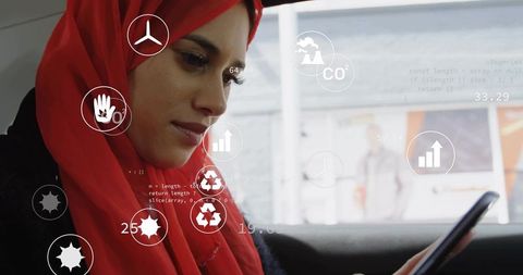 Young muslim woman in red hijab using smartphone with augmented reality overlays in car