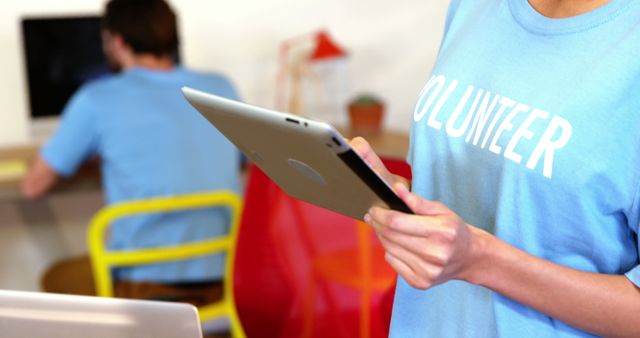 Volunteers working on digital tablets and laptops in community center - Download Free Stock Images Pikwizard.com