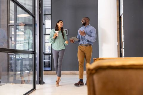 Diverse Coworkers Engaging in Modern Office Corridor