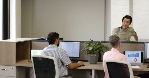 Team collaborating in modern office cubicles with data analysis