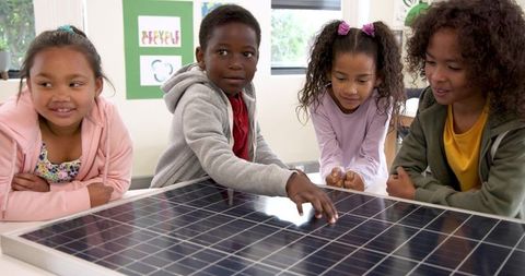 Diverse Children Engaged in Learning with Solar Panel in Eco-Friendly Classroom