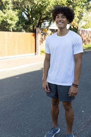 Smiling Young Man in Athletic Wear Enjoying Sunny Day Outdoors