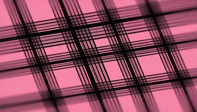 Rotating black plaid grid over vibrant pink field, abstract diagonal geometric texture