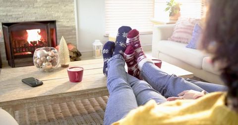 Couple Relaxing by Fireplace in Cozy Living Room Wearing Patterned Socks and Jeans