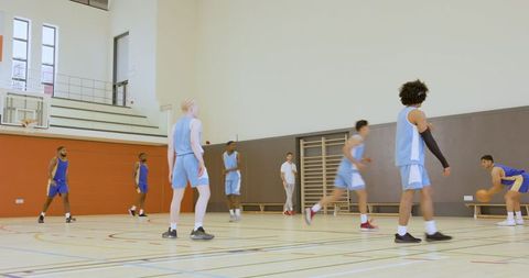 Diverse Team Practicing Basketball Drills in School Gym