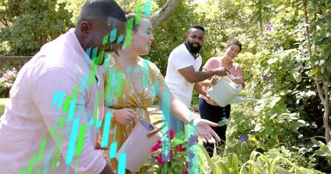 Diverse adults gardening together in sunny backyard with watering cans and flowers
