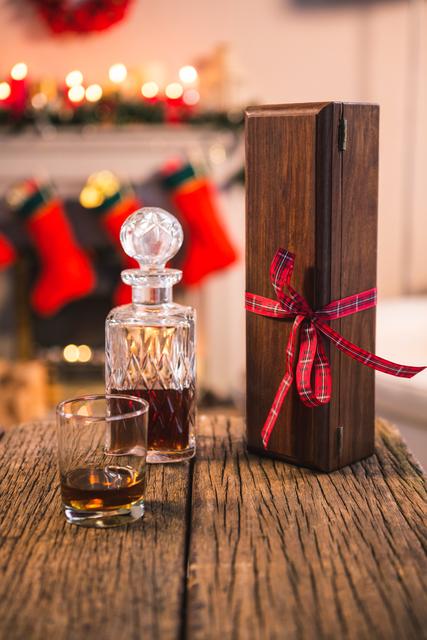 Close-up of bottle of whiskey, glass and gift box on wooden table