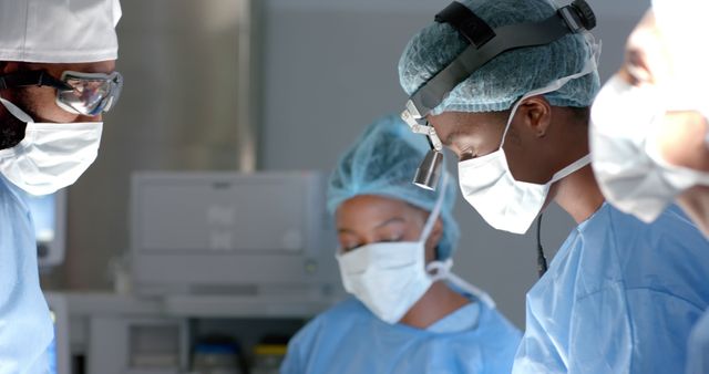 A group of surgeons wearing surgical masks and caps concentratively performing a surgical procedure in a well-equipped operating room. This can be used to illustrate topics related to surgical procedures, medical teamwork, healthcare environments, and hospital operations.