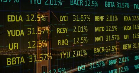 Golden gate bridge glowing at night with stock market tickers overlaying skyline