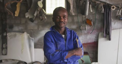Smiling Mechanic in Workshop Holding Wrench - Download Free Stock Images Pikwizard.com