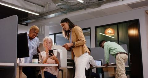 Diverse Team Collaborating Over Smartphone in Modern Office