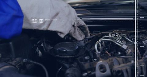 Mechanic wearing white glove checking engine cap with diagnostic overlay and date graphics