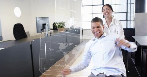 Playful colleagues laughing, pushing coworker in rolling chair, modern office with data overlay