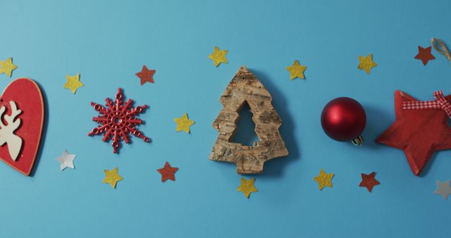 Image of homemade christmas decorations with stars on blue background. christmas, tradition and celebration concept.