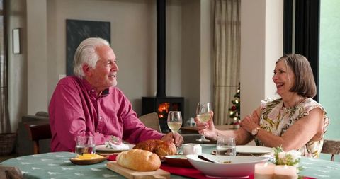 Senior Couple Clinking Glasses in Festive Dining Room
