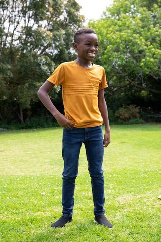 Smiling boy in mustard t-shirt enjoying sunny garden