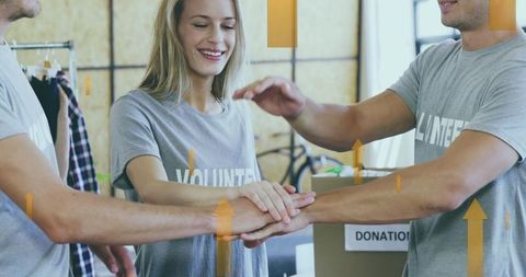 Volunteers Stacking Hands Together Indoors, Empowerment and Team Spirit