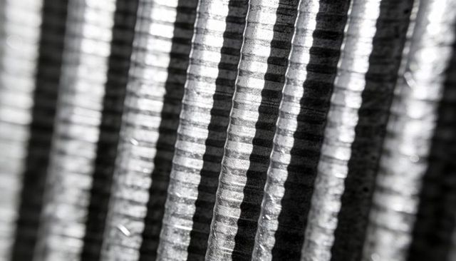 Macro diagonal close-up of ribbed steel rebar with repeating grooves and metallic sheen