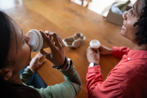 Friends Chatting Over Hot Coffee in Cozy Cafe