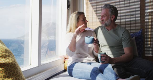 Happy Couple Relaxing by the Window with Ocean View - Download Free Stock Images Pikwizard.com