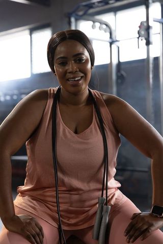 African american woman resting after intense workout with jump rope in industrial gym
