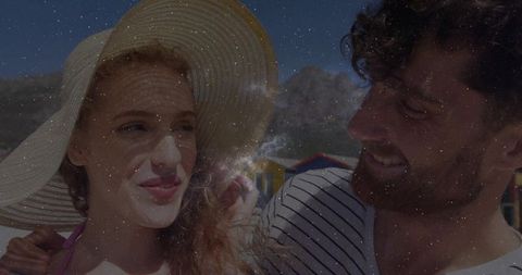 Summer Romance by the Sea: Smiling Couple at Beach with Vibrant Cabins