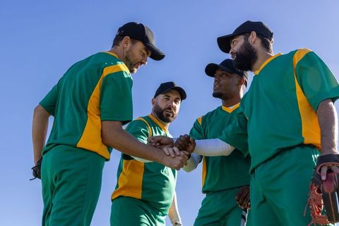 Baseball team stacking hands in pregame huddle showing unity, focus, leadership