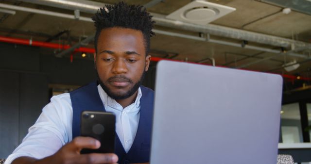 Focused Man Using Smartphone and Laptop in Modern Office - Download Free Stock Images Pikwizard.com